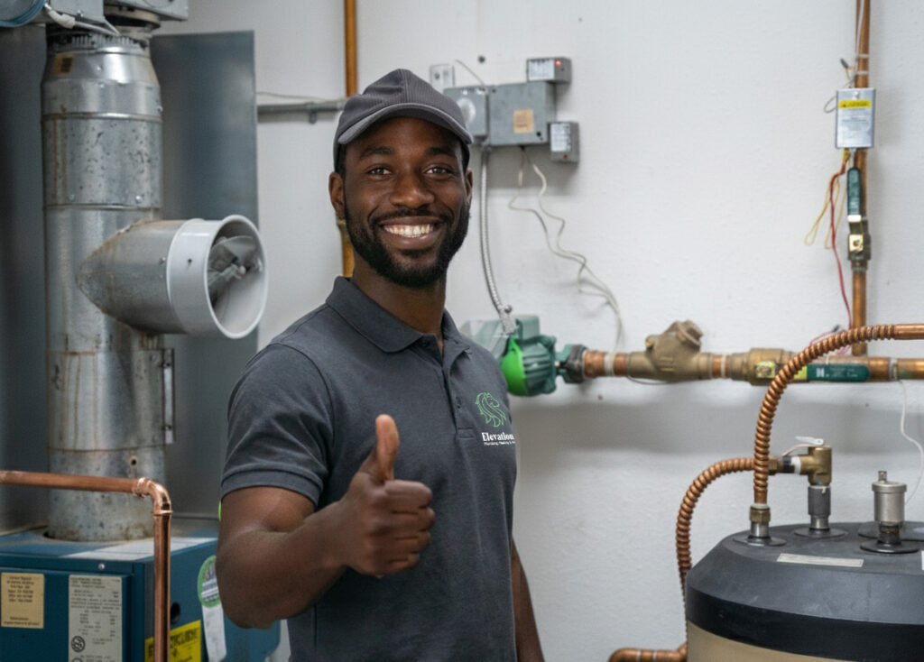 Elevation technician giving a thumbs up beside a newly serviced water heater